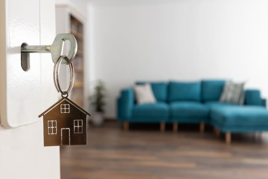 Ein Schlüssel mit einem Haus-Anhänger steckt im Schloss, Symbol für professionelle Immobilienvermietung und zuverlässigen Vermietungspartner.